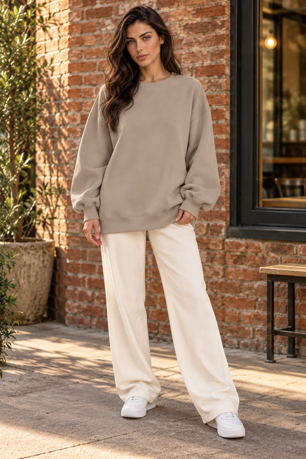 Woman at a cafe wearing the EFAN oversized crewneck
