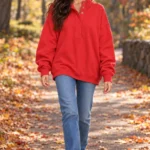 Woman in the Gacaky red oversized Henley sweatshirt on a park path